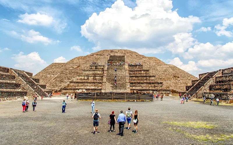 Tour group walking the Avenue of the Dead toward the Pyramid of the Sun on a morning Teotihuacan pyramids tour from Mexico City